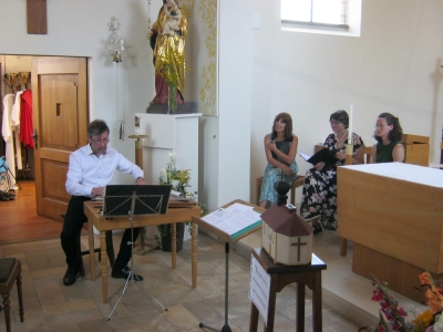 Klaus Schauer an der Zither, sitzend der Frauenchor